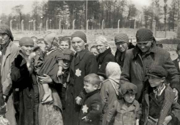 Prisoners at Auschwitz gather outside perimeter fence